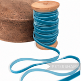 Petershams Millinery Supplies 7mm vintage blue velvet ribbon on a wooden spool next to a wooden millinery block