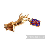 Petershams Millinery Supplies vintage 1940s gold-tone brooch featuring a hand dangling a Union Jack flag