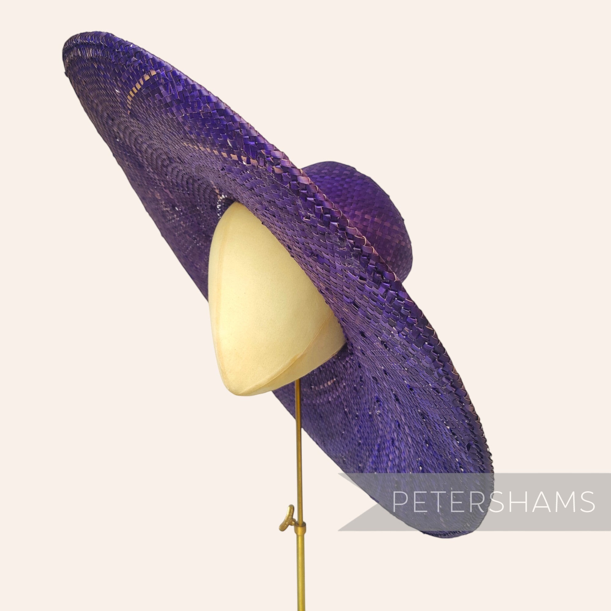 Petershams Millinery Supplies purple XL strip straw capeline hat body with a wide 15-inch brim on a millinery block.