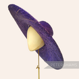 Petershams Millinery Supplies purple XL strip straw capeline hat body with a wide 15-inch brim on a millinery block.