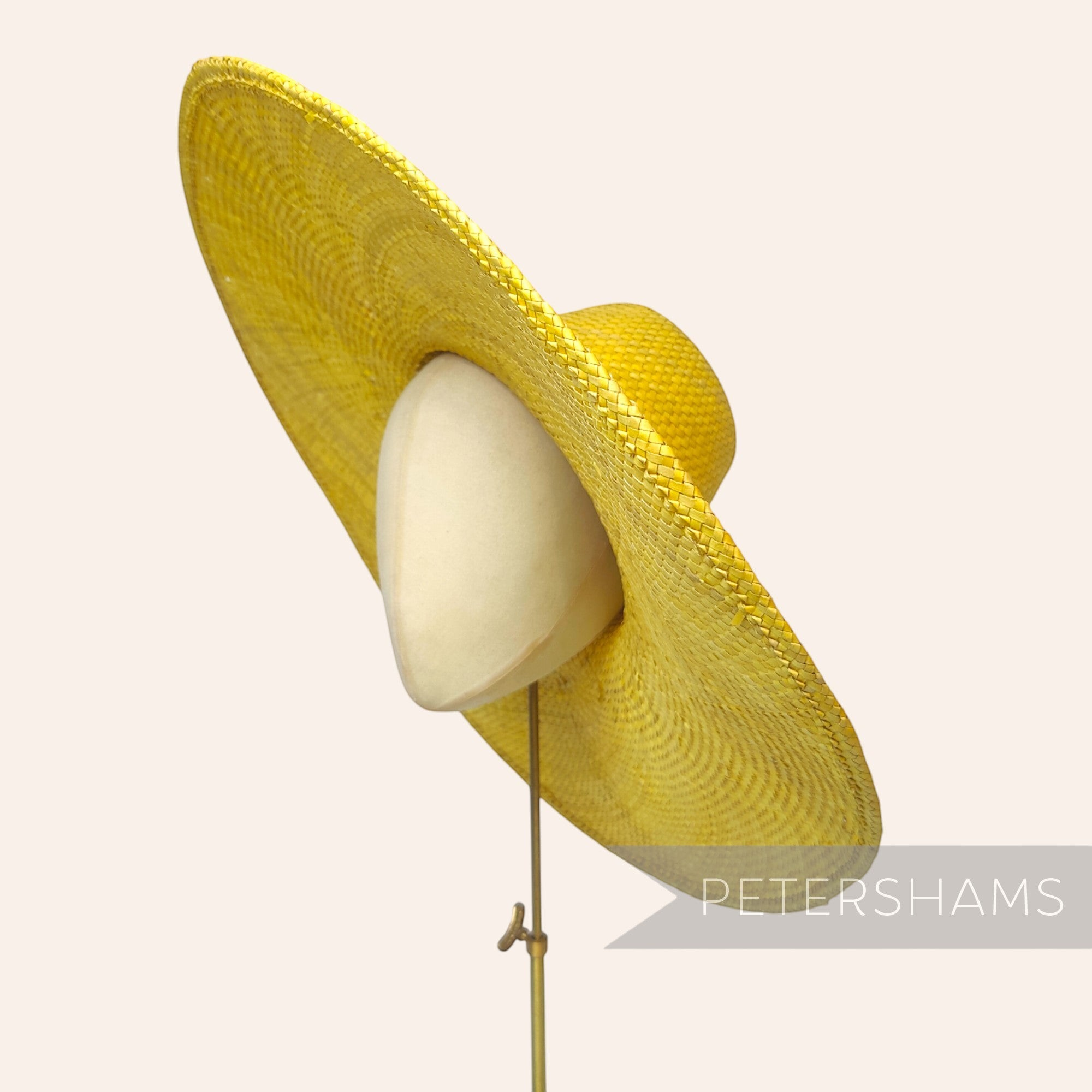 Petershams Millinery Supplies yellow XL strip straw capeline hat body with a wide brim on a millinery head form