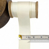 Petershams Millinery Supplies 38mm cream polyester grosgrain ribbon on a wooden spool with a measuring tape