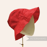 Petershams Millinery Supplies vintage red nylon children's bucket hat with a foldable design on a mannequin head.