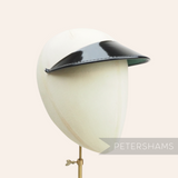 Petershams black patent leather cap peak with glossy top, pine green underside and patent tape trim. Made in England.