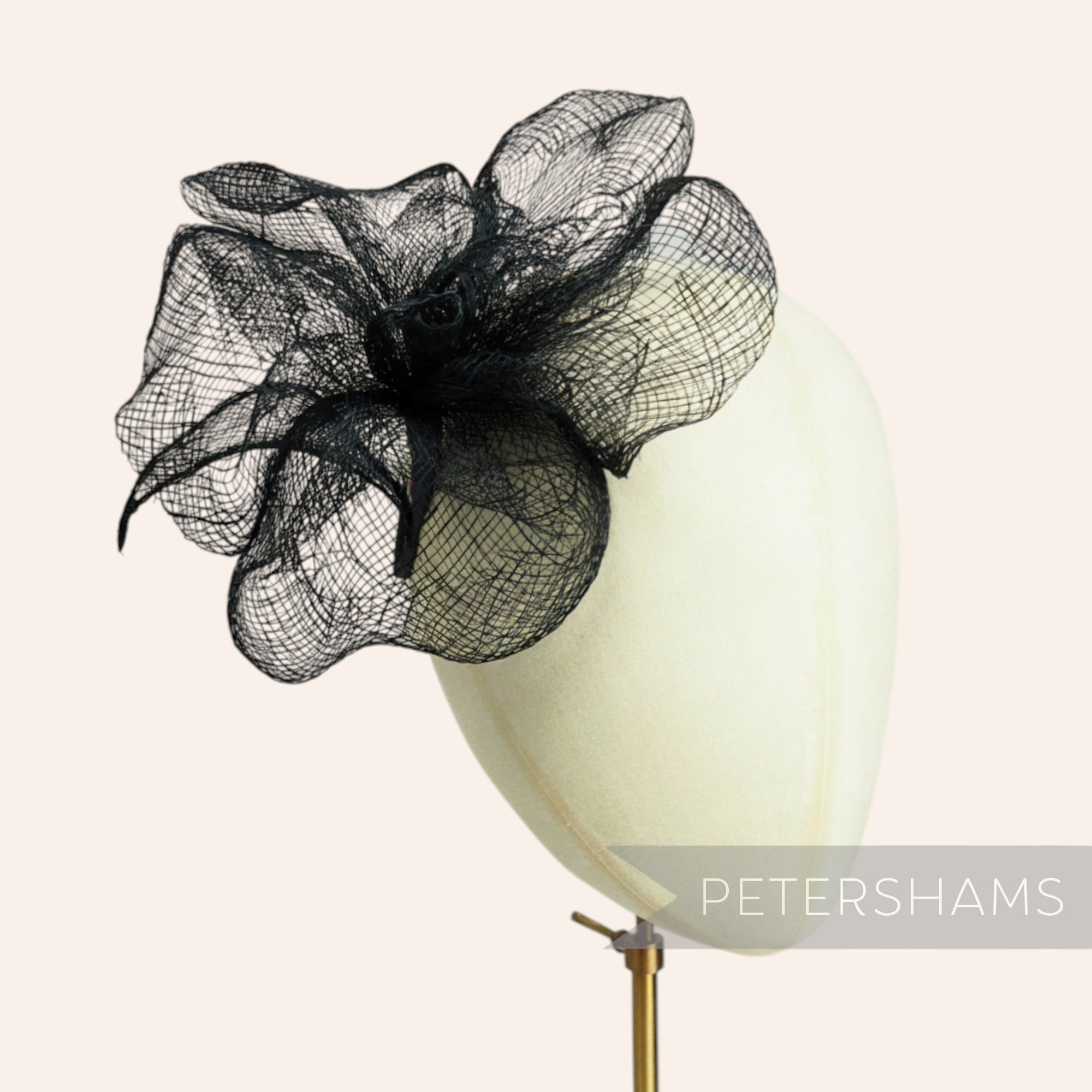 Petershams Millinery Supplies black sinamay flower mount with frilly petals and a single leaf, 20cm wide.