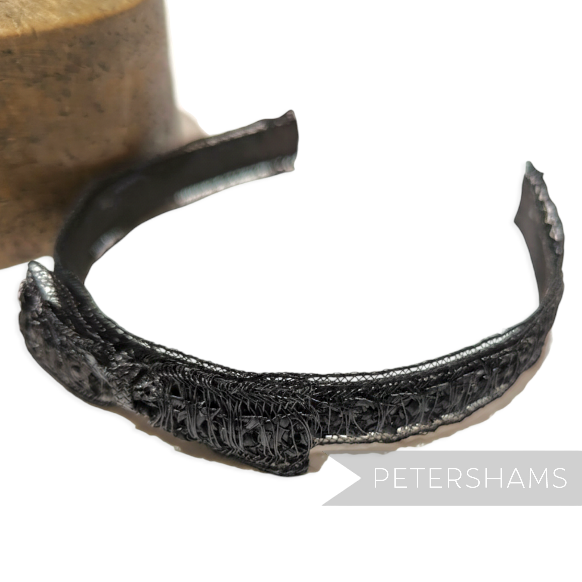 Petershams black vintage laminated raffia and crin braid headband with a small bow detail.