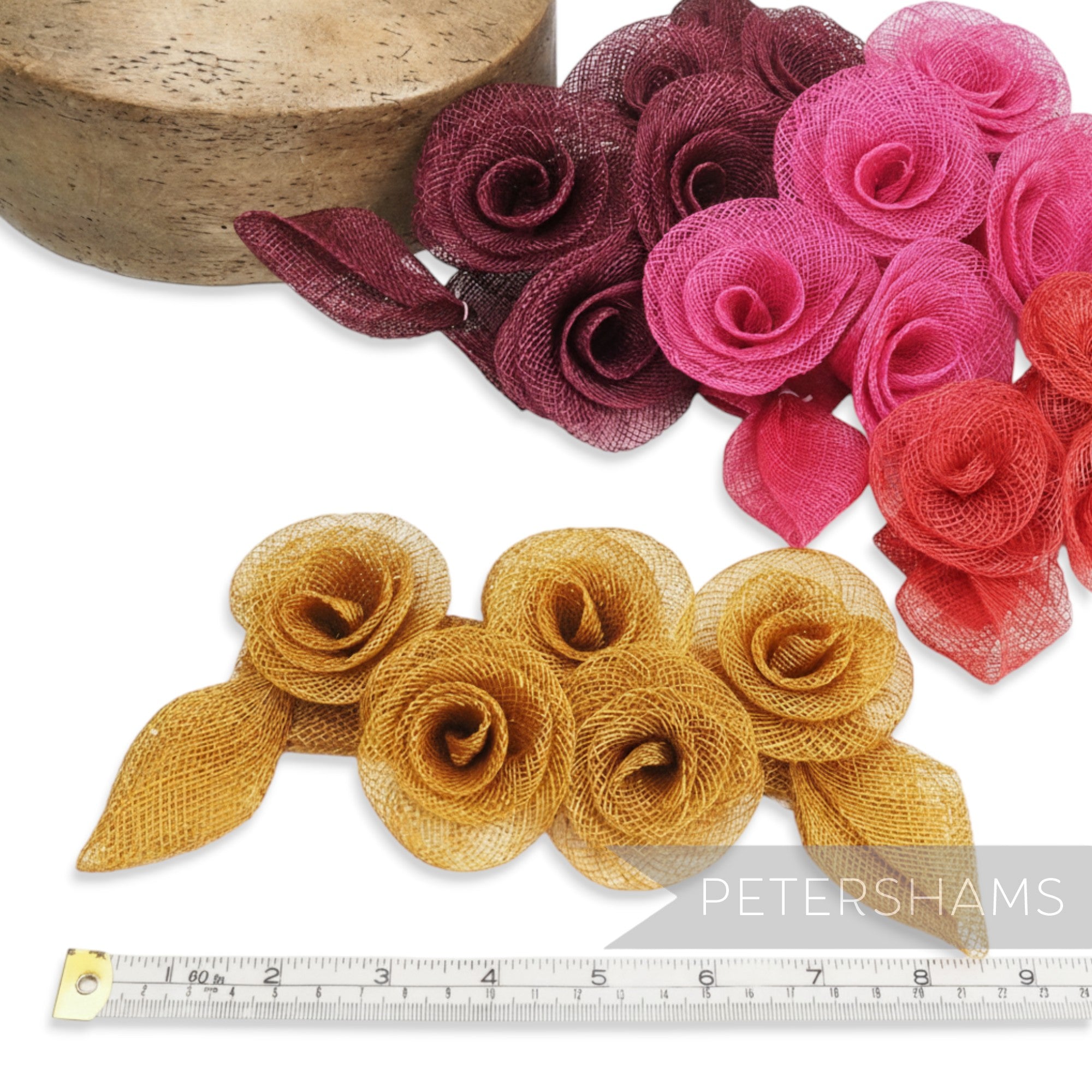Petershams Millinery Supplies 'Florence' sinamay mount with five rose-style flowers and leaves in gold, pink, red, and burgundy.