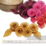 Petershams Millinery Supplies 'Florence' sinamay mount with five rose-style flowers and leaves in gold, pink, red, and burgundy.