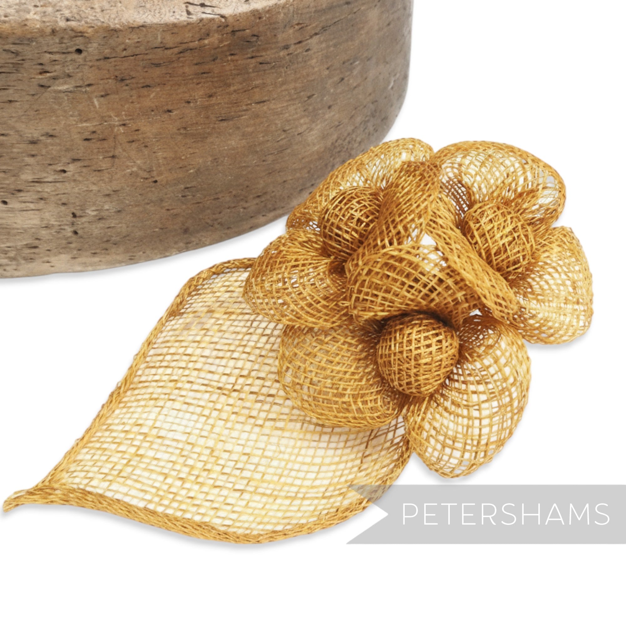 Petershams Millinery Supplies golden sinamay hat mount with triple flowers and leaf backing.