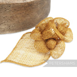 Petershams Millinery Supplies golden sinamay hat mount with triple flowers and leaf backing.