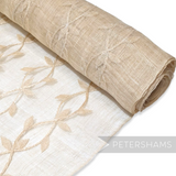 Petershams Millinery Supplies beige sinamay abaca fabric with applique leaf vine pattern on a rolled bolt.
