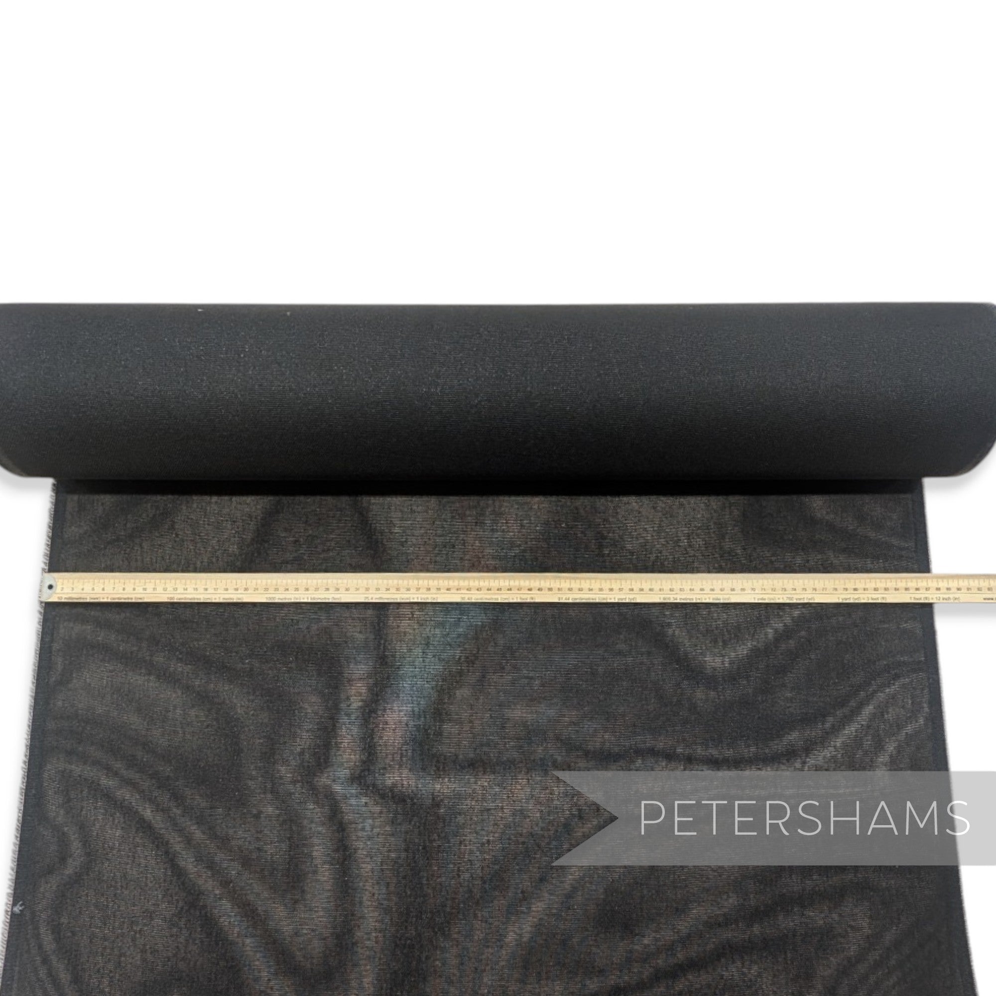 Petershams Millinery Supplies black double sided stiffened cotton buckram fabric roll with a measuring ruler on top.