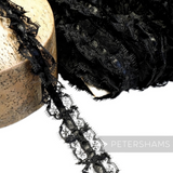 Petershams Millinery Supplies 25mm black frilly lace trim with a central satin ribbon detail on a wooden block