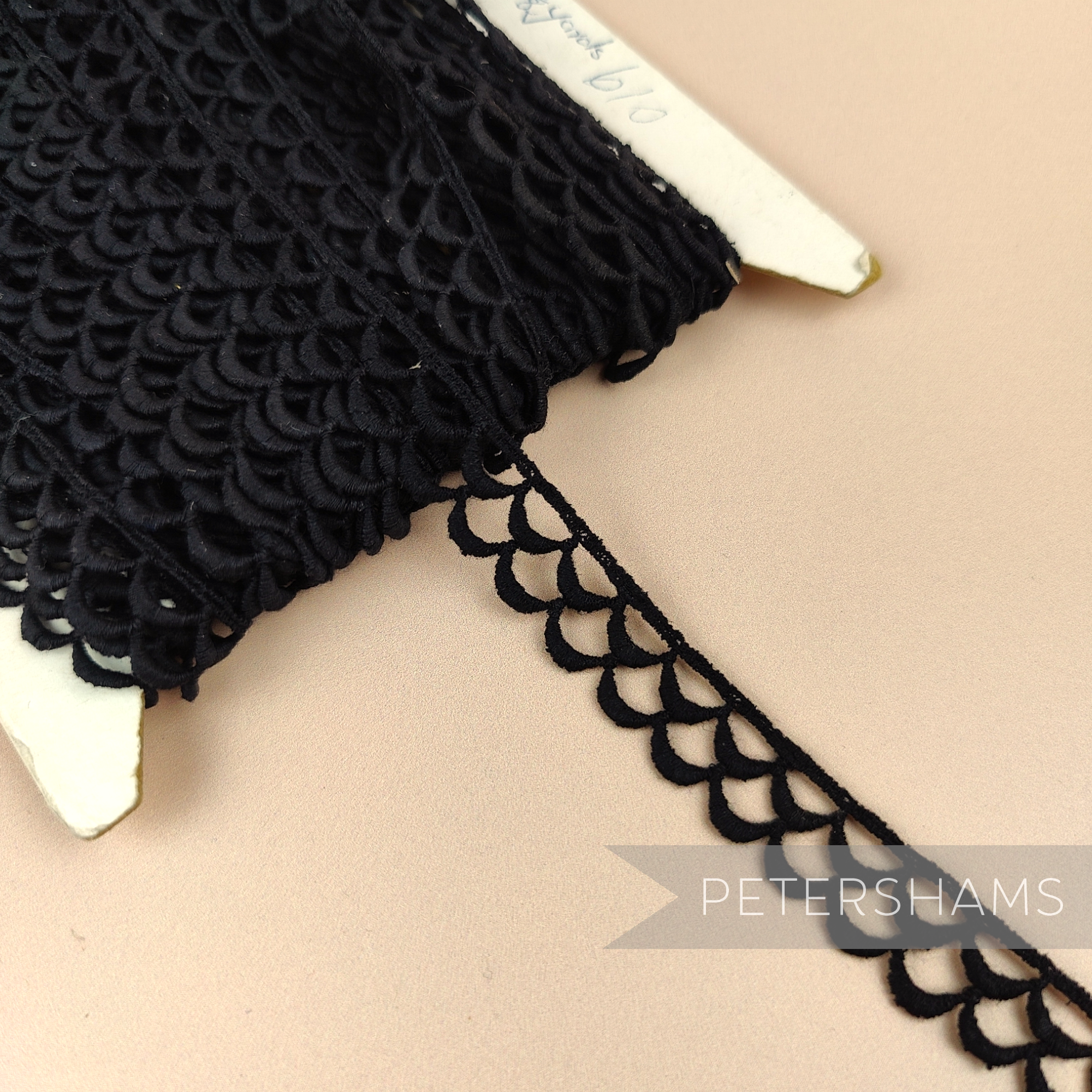 Petershams Millinery Supplies vintage black 13mm guipure lace trim with a delicate eyelash wheel design on a spool.