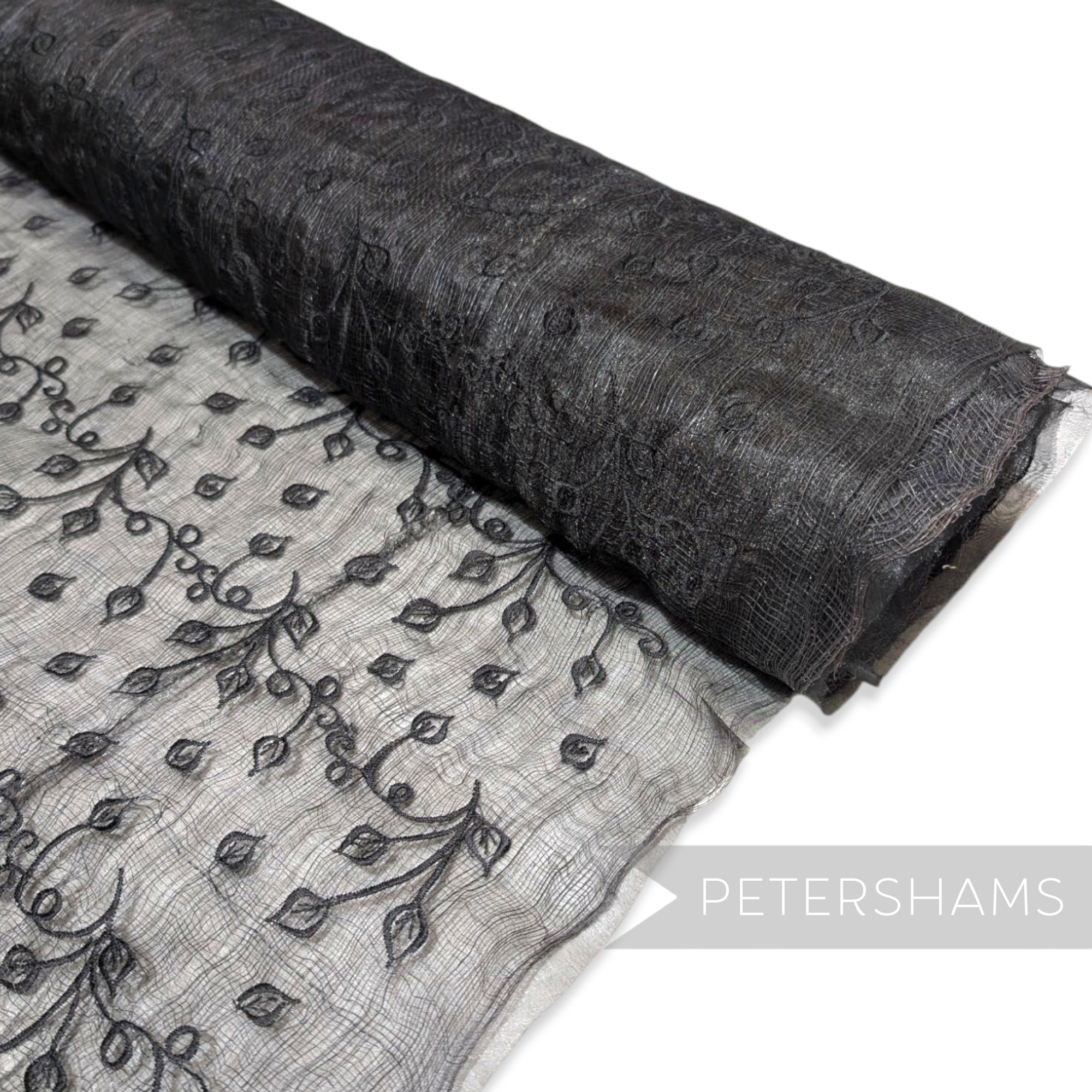 Petershams Millinery Supplies black sinamay fabric with leaf embroidery and organza backing on a roll.