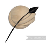 Petershams Millinery Supplies black arrowhead turkey quill feather displayed on a wooden millinery block
