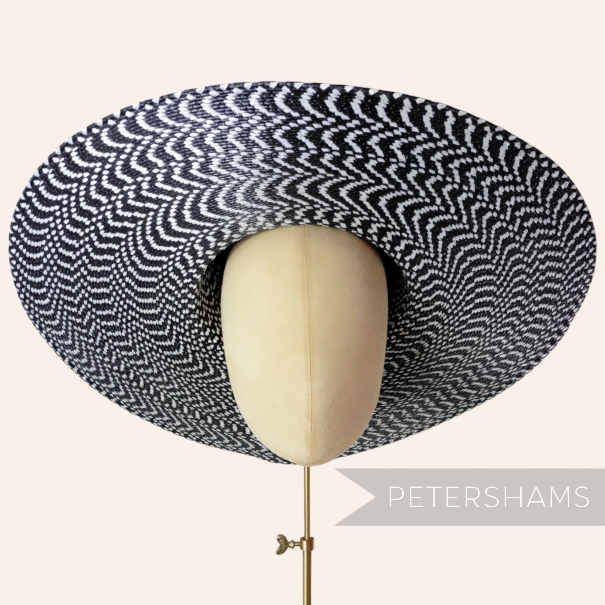 Petershams Millinery Supplies black and white polybraid capeline hat body with a wide, undulating brim.