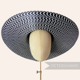 Petershams Millinery Supplies black and white polybraid capeline hat body with a wide, undulating brim.