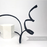 Petershams Millinery Supplies black crin and sinamay wired visor fascinator base with a decorative swirling trim.