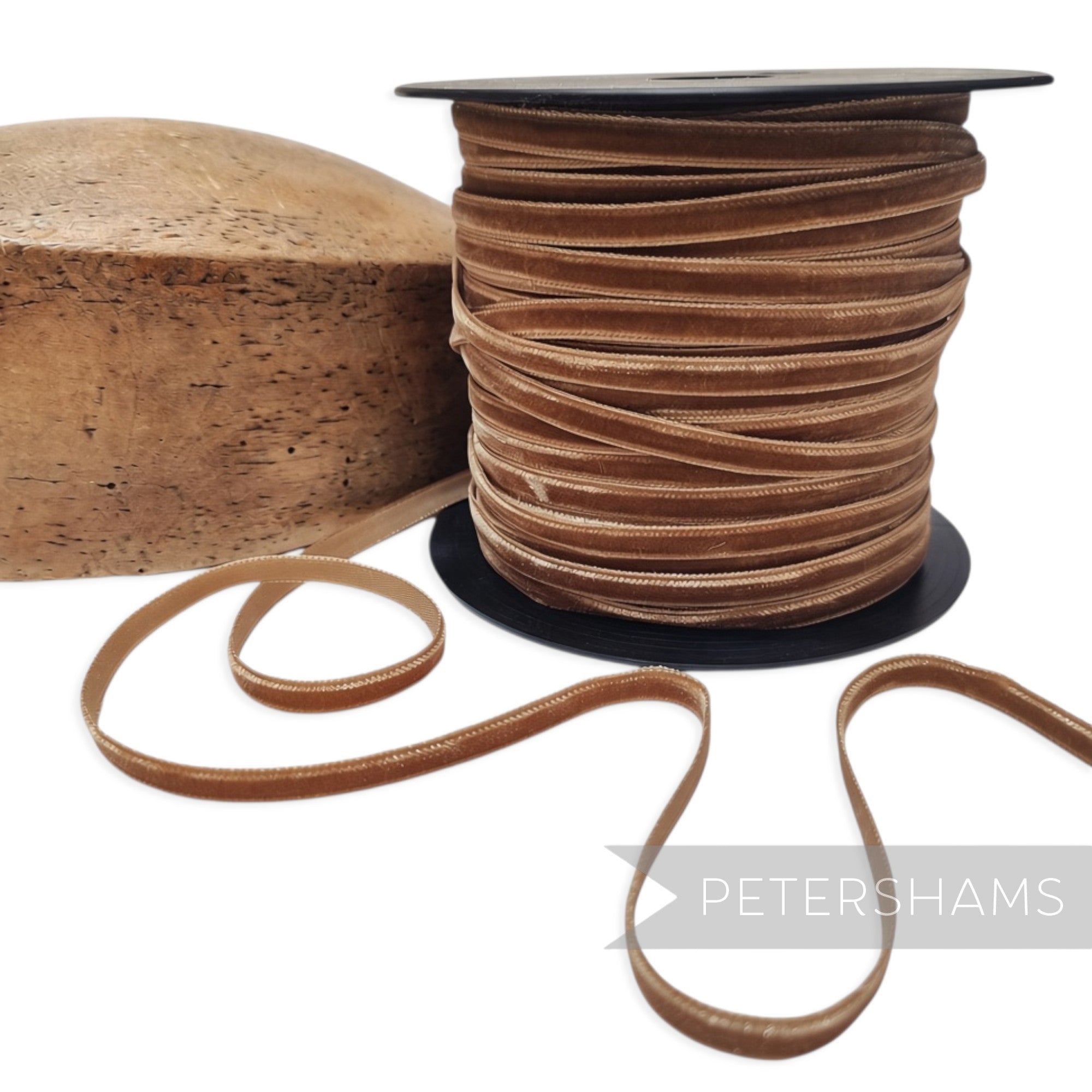 Petershams Millinery Supplies 7mm toast brown French velvet ribbon on a spool next to a wooden hat block