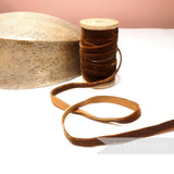 Petershams Millinery Supplies 10mm vintage brown velvet ribbon on a wooden spool next to a millinery hat block
