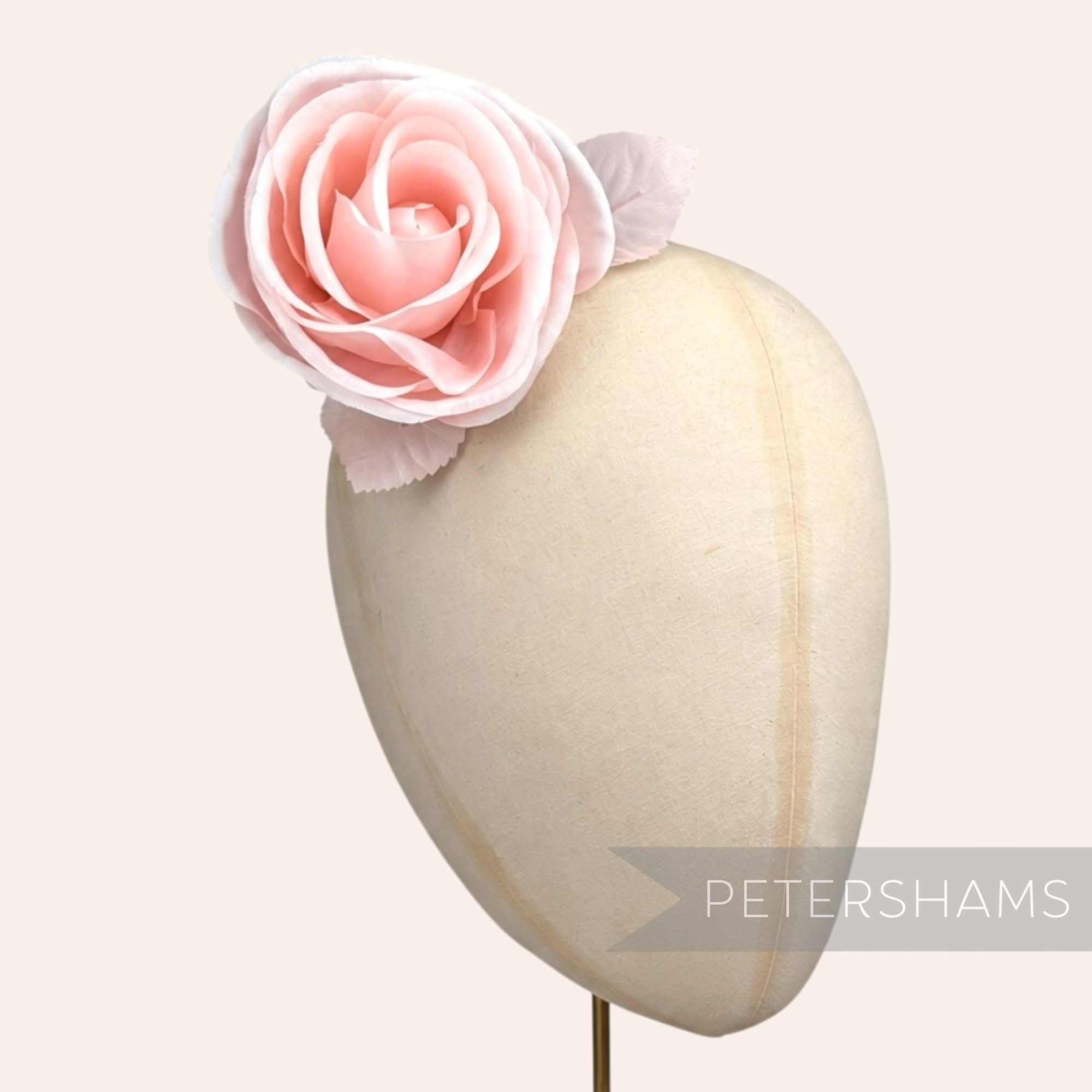Petershams Millinery Supplies Carmel light pink silk rose flower hat mount on a millinery display head.