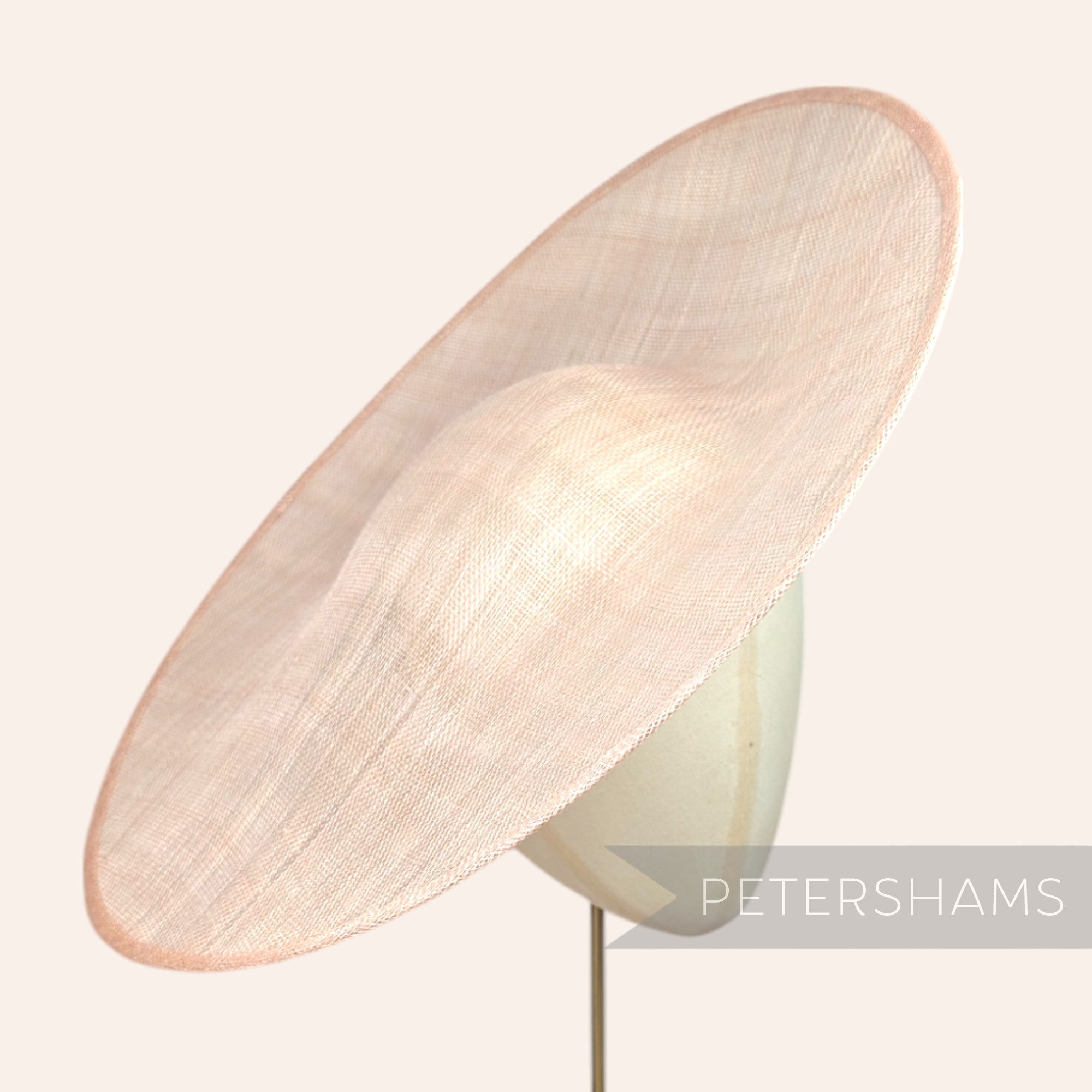 Petershams Millinery Supplies Catherine XL sloped sinamay fascinator hat base in a light beige circular shape.