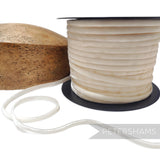Petershams Millinery Supplies 7mm ivory French velvet ribbon on a spool next to a wooden hat block