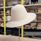 Petershams Millinery Supplies off-white wool felt capeline hat body on a stand in a millinery workshop