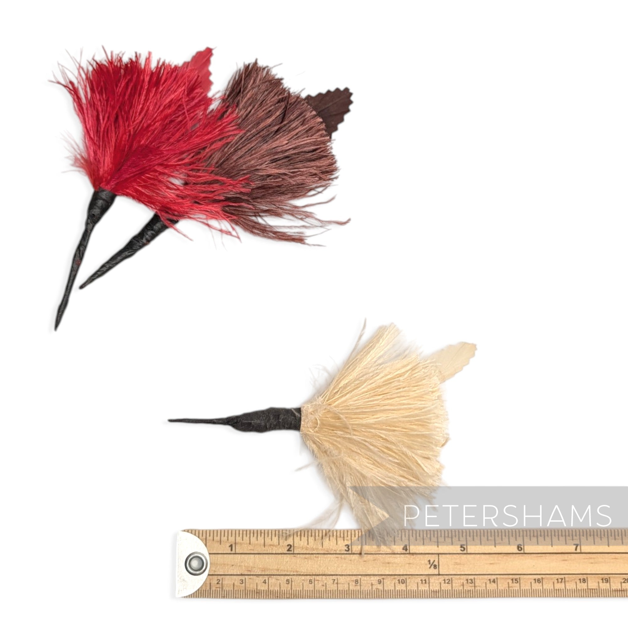 Petershams Millinery Supplies ostrich and goose feather hat mounts in red, brown, and cream with wired stems.