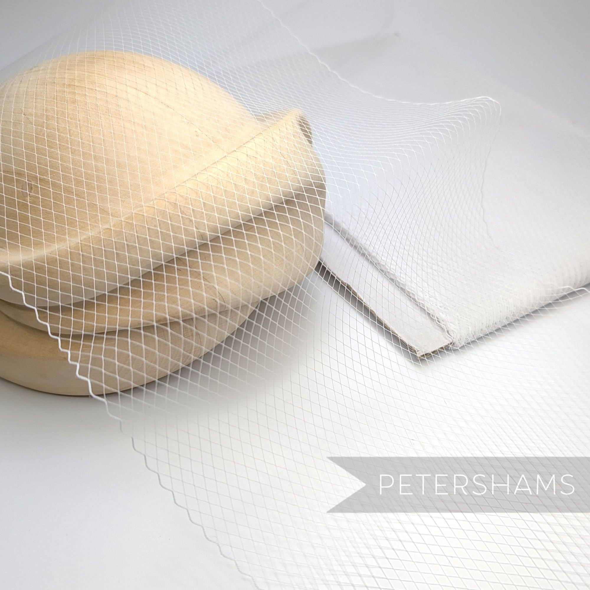 Petershams Millinery Supplies fine weave veiling with 5mm diamonds and scalloped edge draped over a wooden hat block
