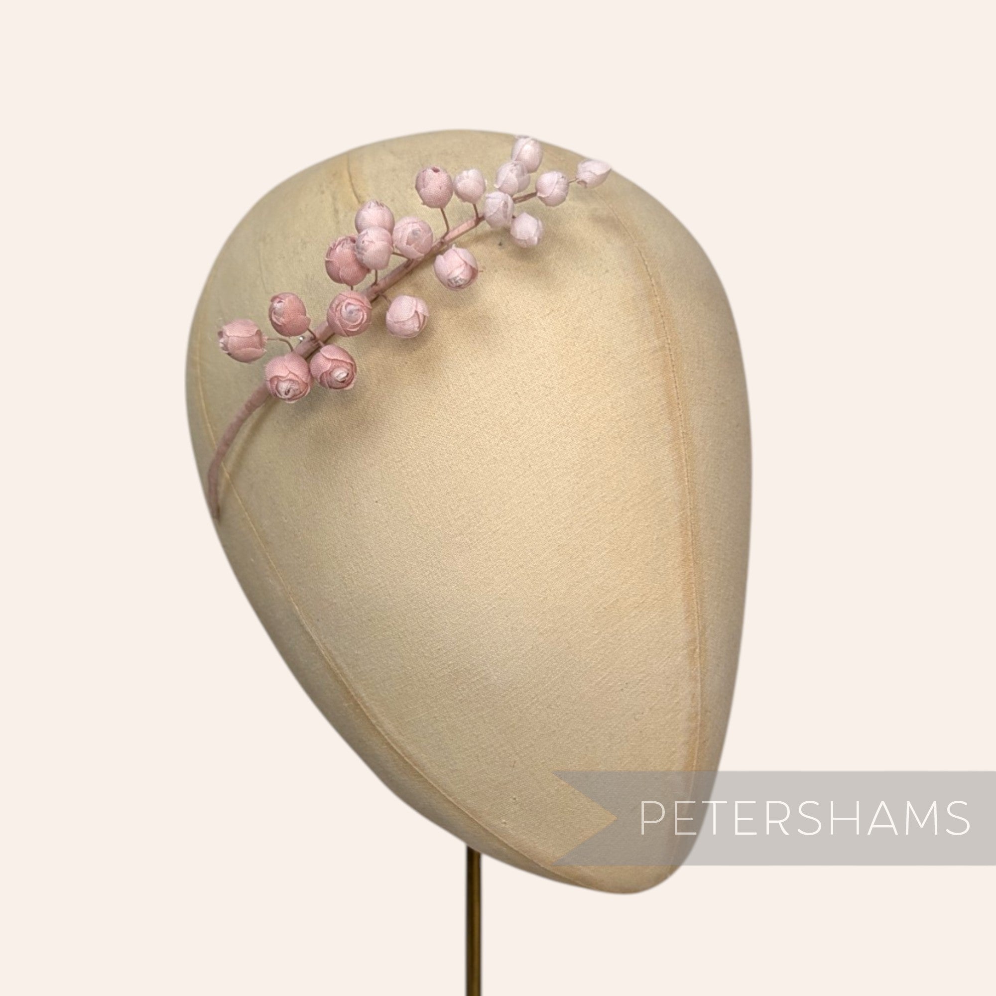 Petershams Millinery Supplies Giselle mini silk wired rosebud hat mount in soft pink on a millinery head form.