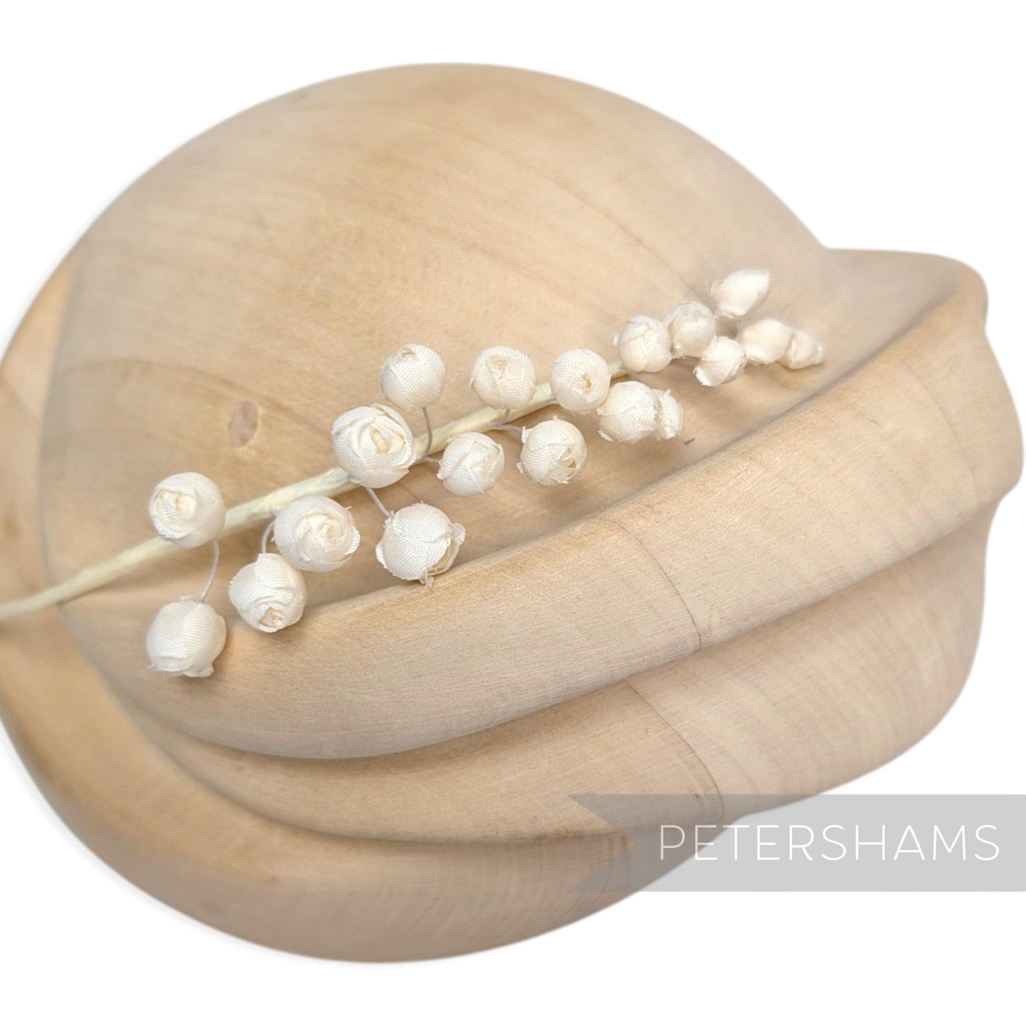 Petershams Millinery Supplies Giselle mini silk wired rosebud hat mount on a wooden millinery block