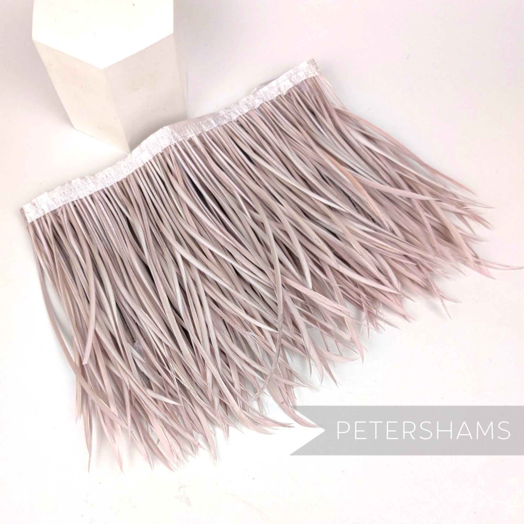Petershams Millinery Supplies extra long goose biot feather fringe in a soft rose pink shade with satin ribbon binding.