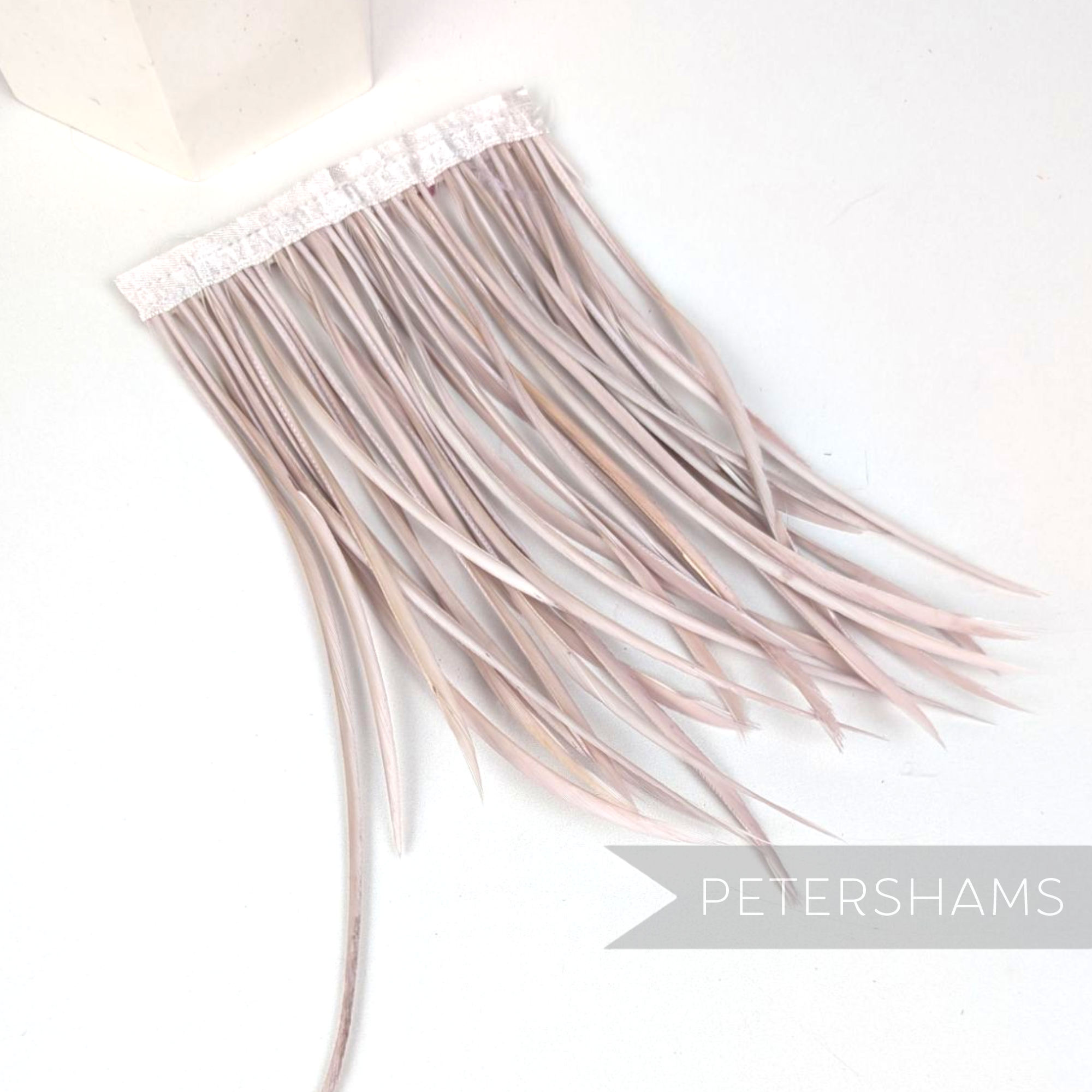 Petershams Millinery Supplies extra long rose pink goose biot feather fringe on a white satin ribbon binding