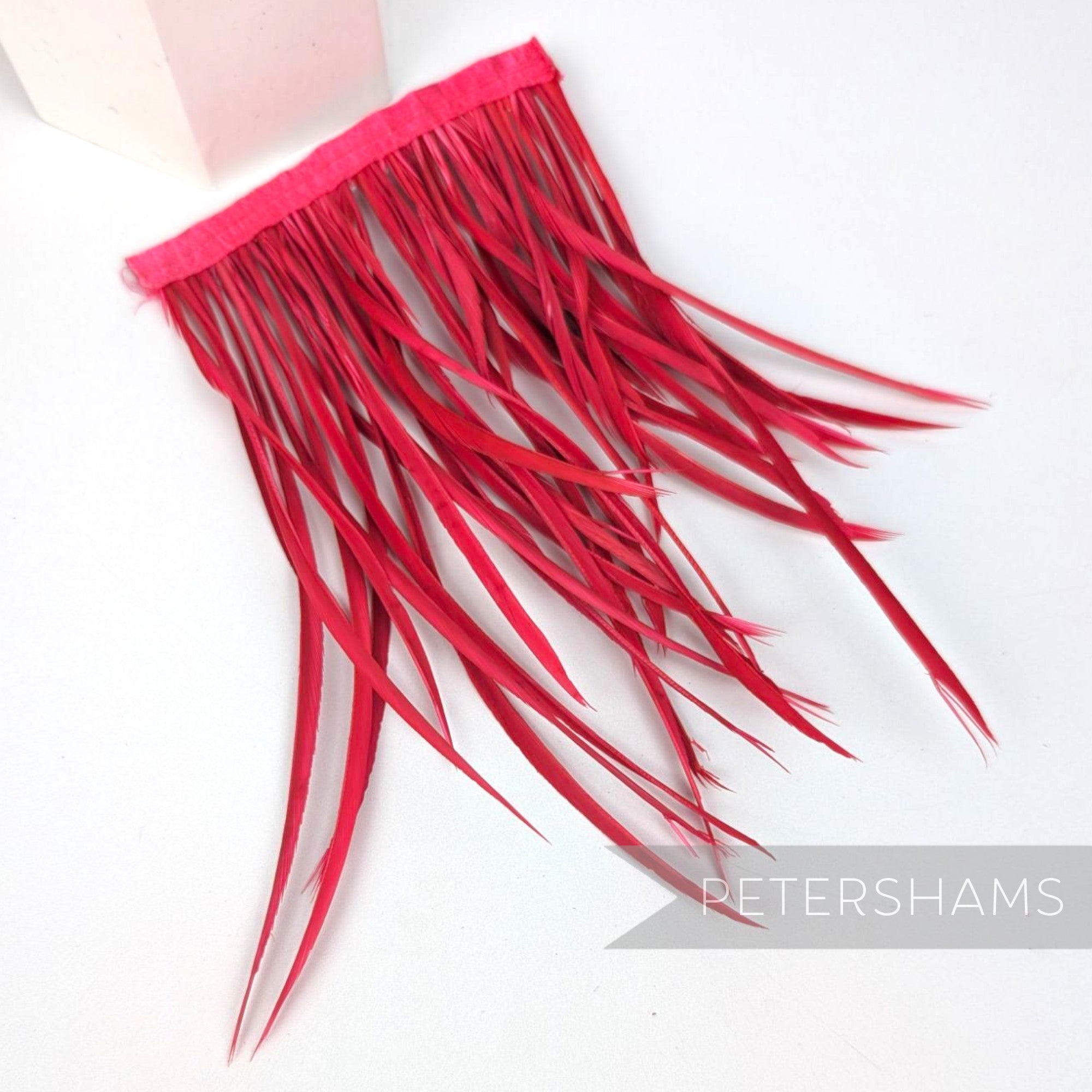 Petershams Millinery Supplies extra long fuchsia goose biot feather fringe on a stitched satin ribbon binding.