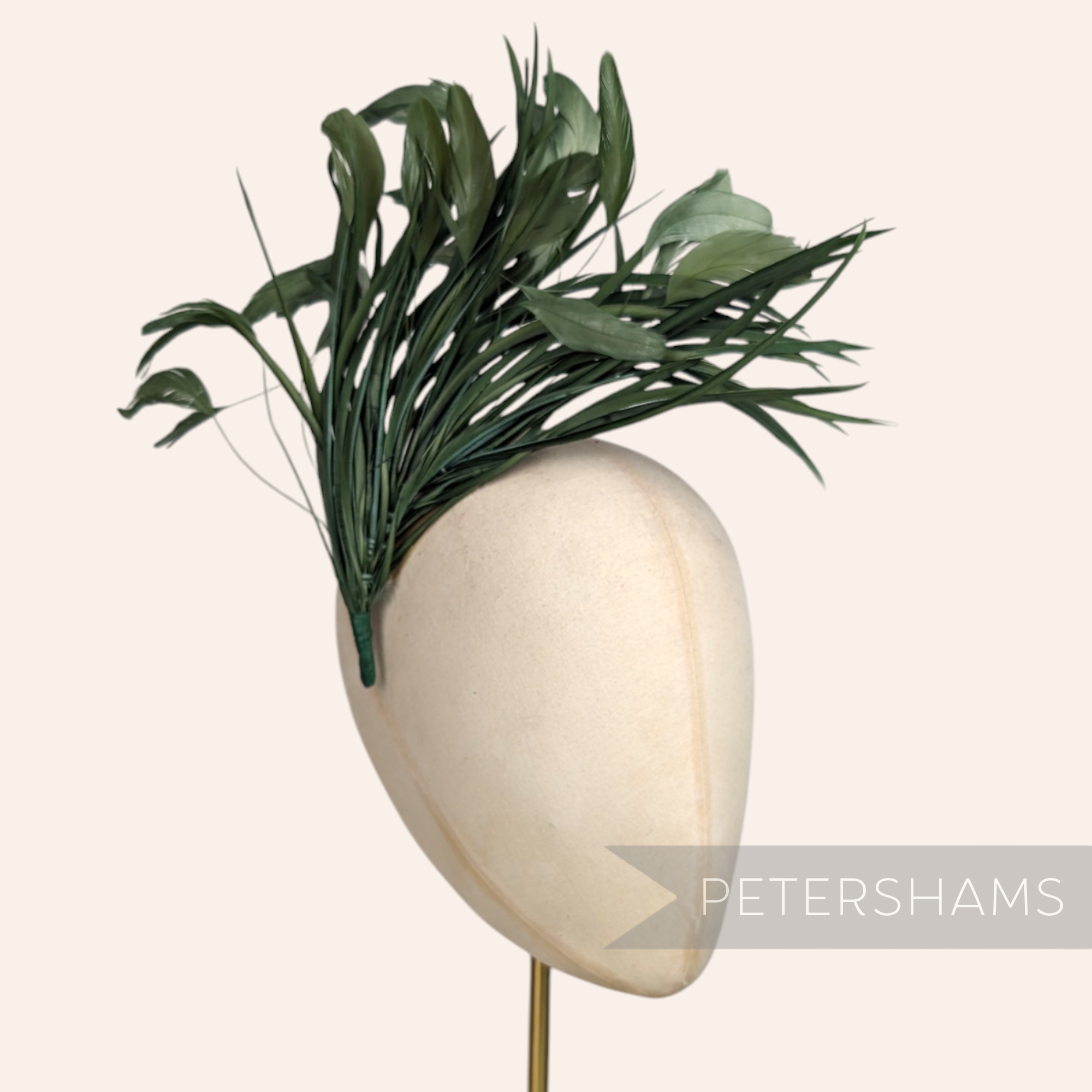 Petershams Millinery Supplies extra large dark green stripped coque and goose biot feather hat mount on a head form.