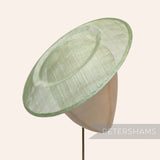 Petershams Millinery Supplies large round sage green sinamay fascinator hat base on a mannequin head
