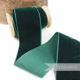 Petershams Millinery Supplies 50mm wide bottle green French velvet ribbon on a wooden spool with a luxurious sheen.