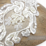 Petershams Millinery Supplies white heart-shaped lace motif with faux pearls and iridescent sequins for bridal wear.