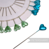 Petershams Millinery Supplies vintage inspired heart sewing pins in teal and green on a white storage wheel.