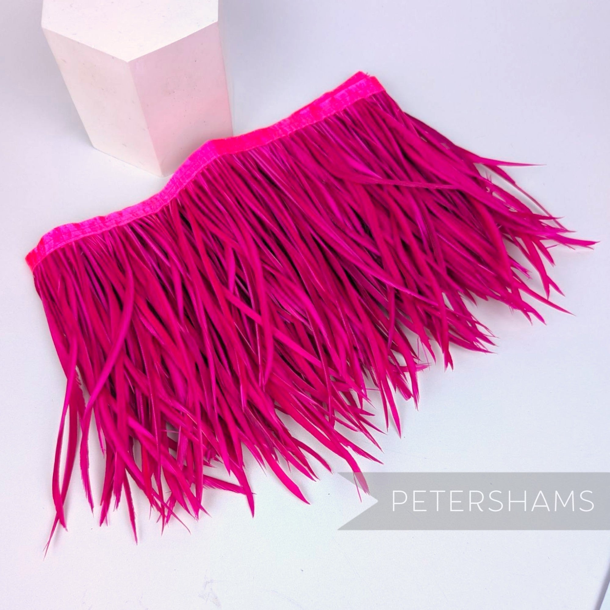 Petershams Millinery Supplies extra long neon pink goose biot feather fringe on a satin ribbon binding