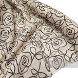 Petershams Millinery Supplies ivory jute-like cotton fabric featuring a black rose print, ideal for hat trimming.