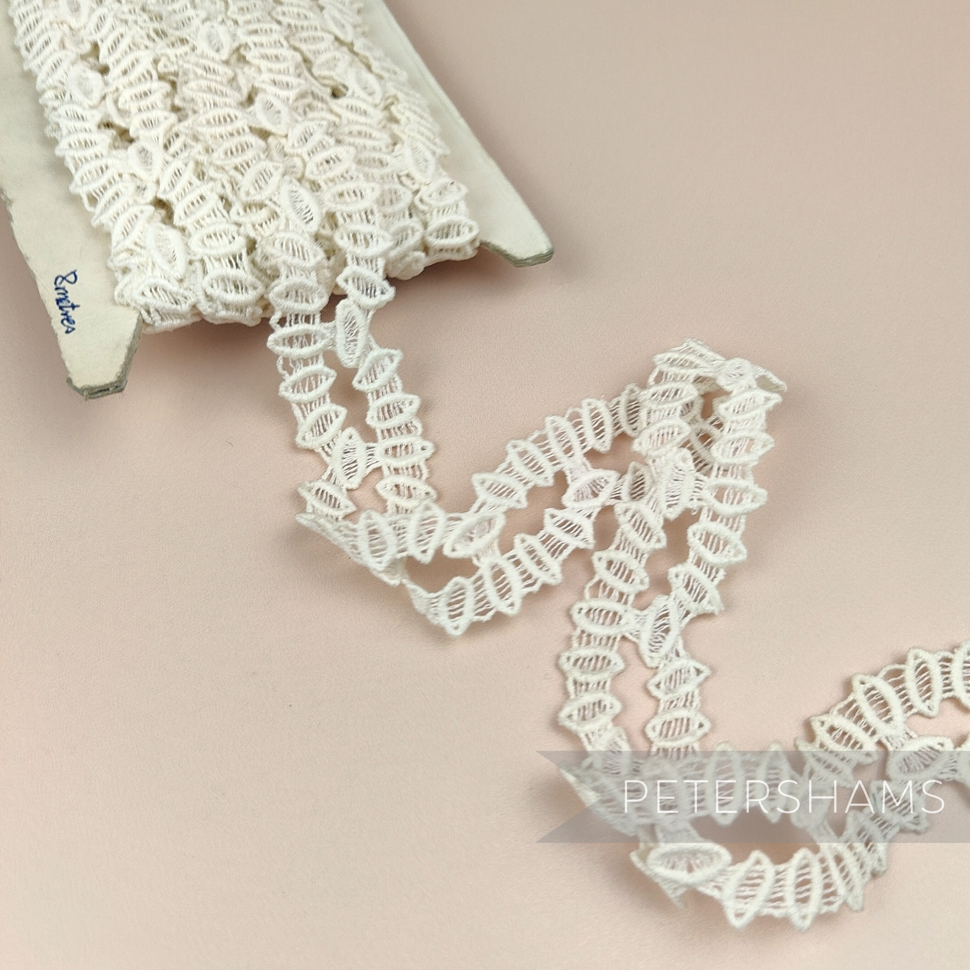 Petershams Millinery Supplies vintage 1950s ivory cotton guipure lace trim with a geometric horn scallop design.