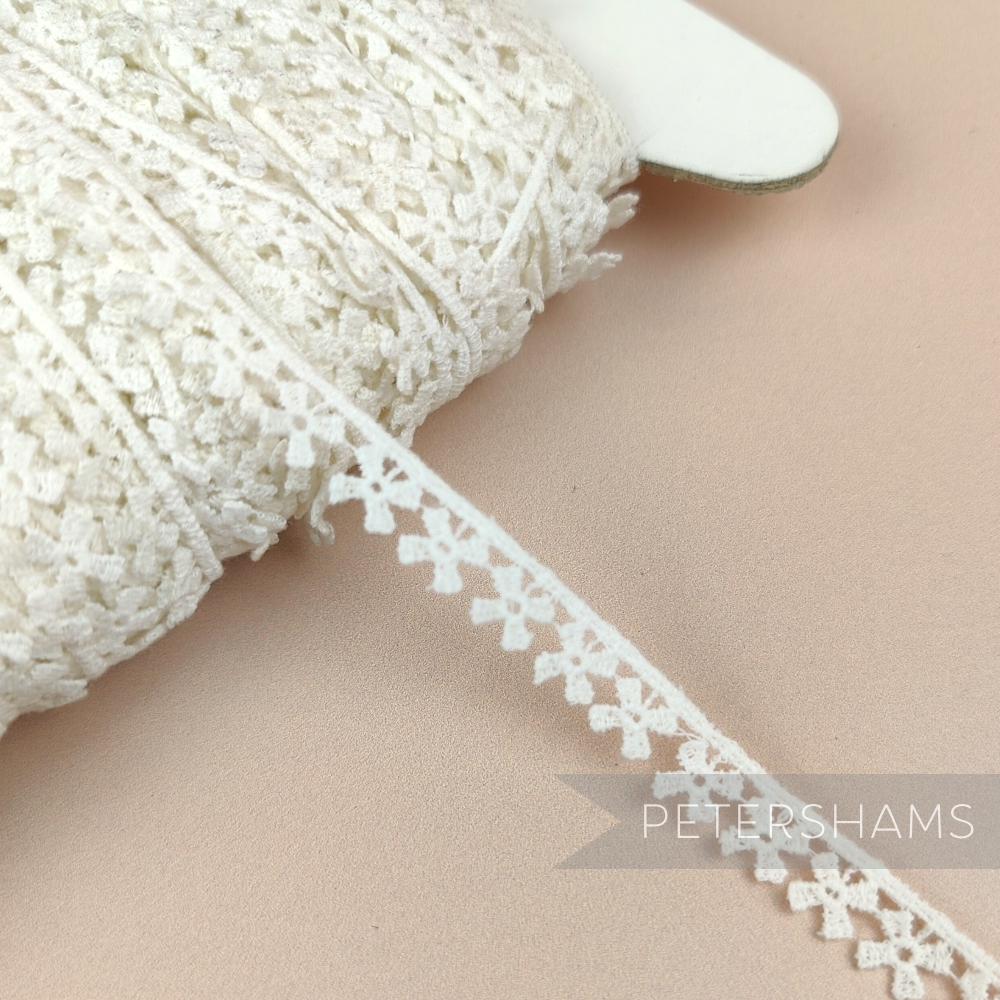 Petershams Millinery Supplies vintage 10mm ivory cotton guipure lace trim with a delicate windmill pattern on a spool.