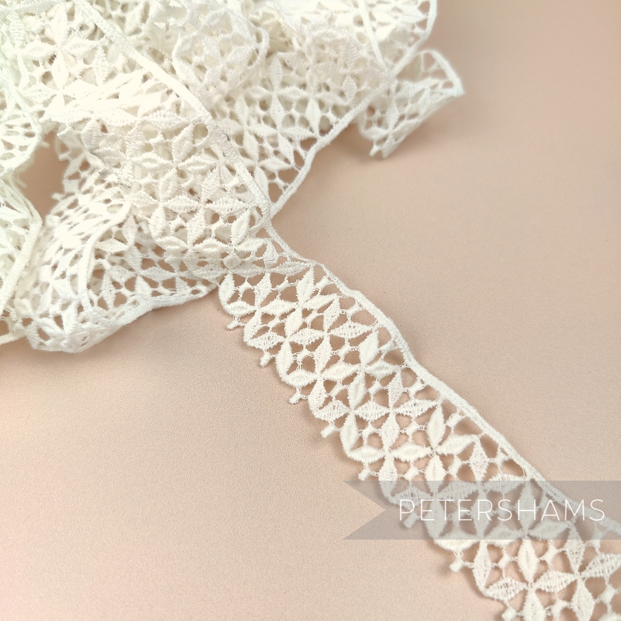 Petershams Millinery Supplies vintage 1950s ivory cotton guipure lace trim with a bold graphic flower design