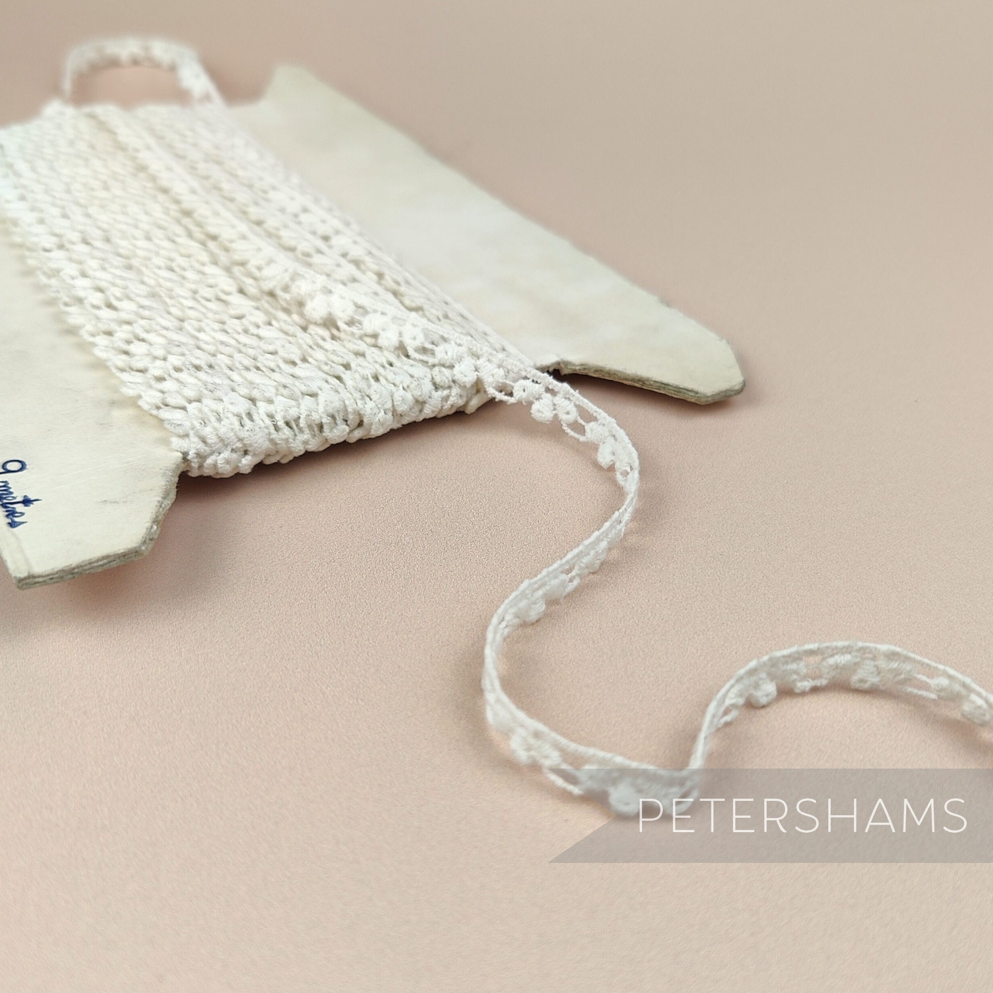 Petershams Millinery Supplies vintage 8mm ivory cotton guipure lace trim with a spotted club and swag pattern.