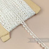 Petershams Millinery Supplies 10mm ivory cotton guipure lace trim with vintage eyelash peephole pattern on a spool.