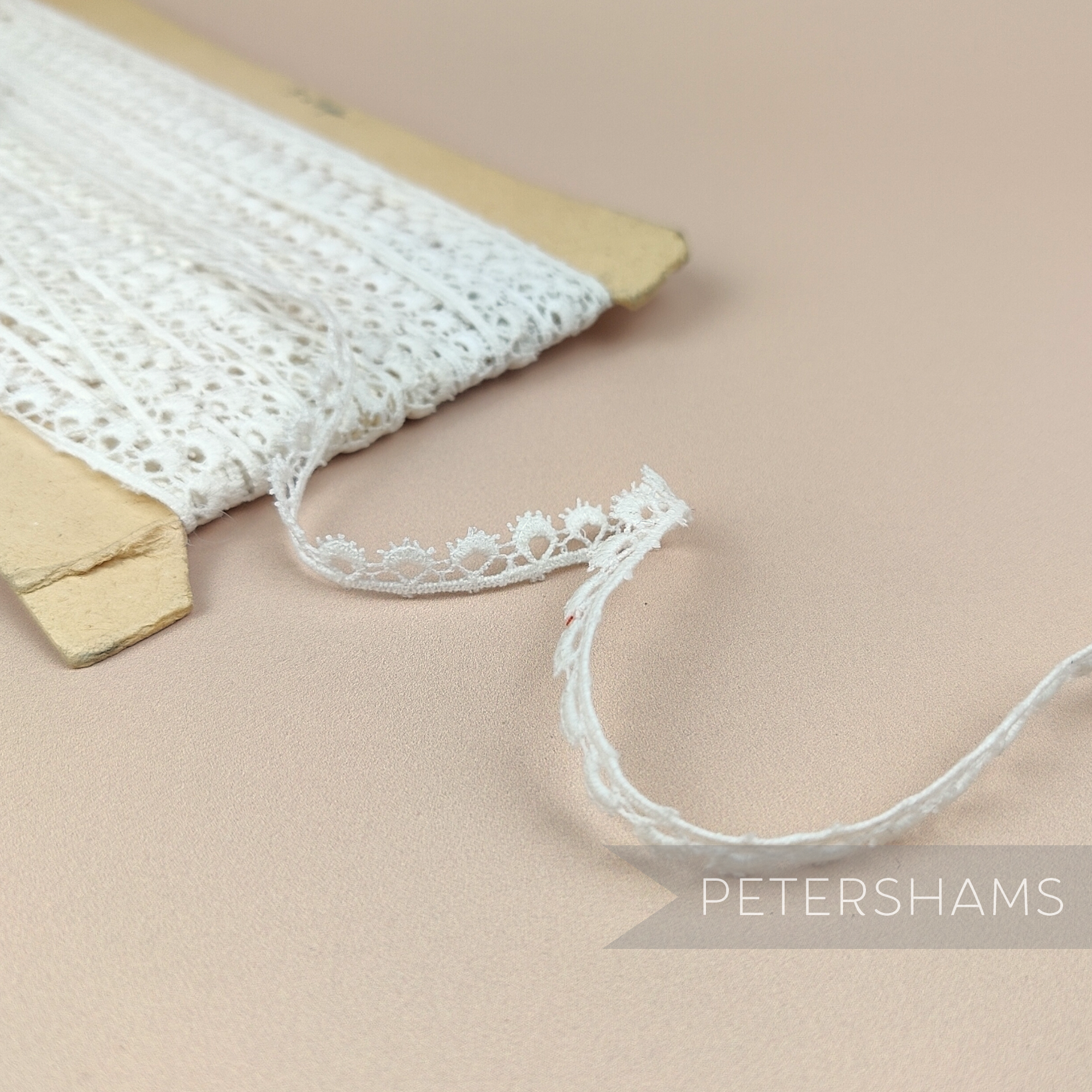 Petershams Millinery Supplies 10mm ivory cotton guipure lace trim with vintage eyelash peephole pattern on a spool.