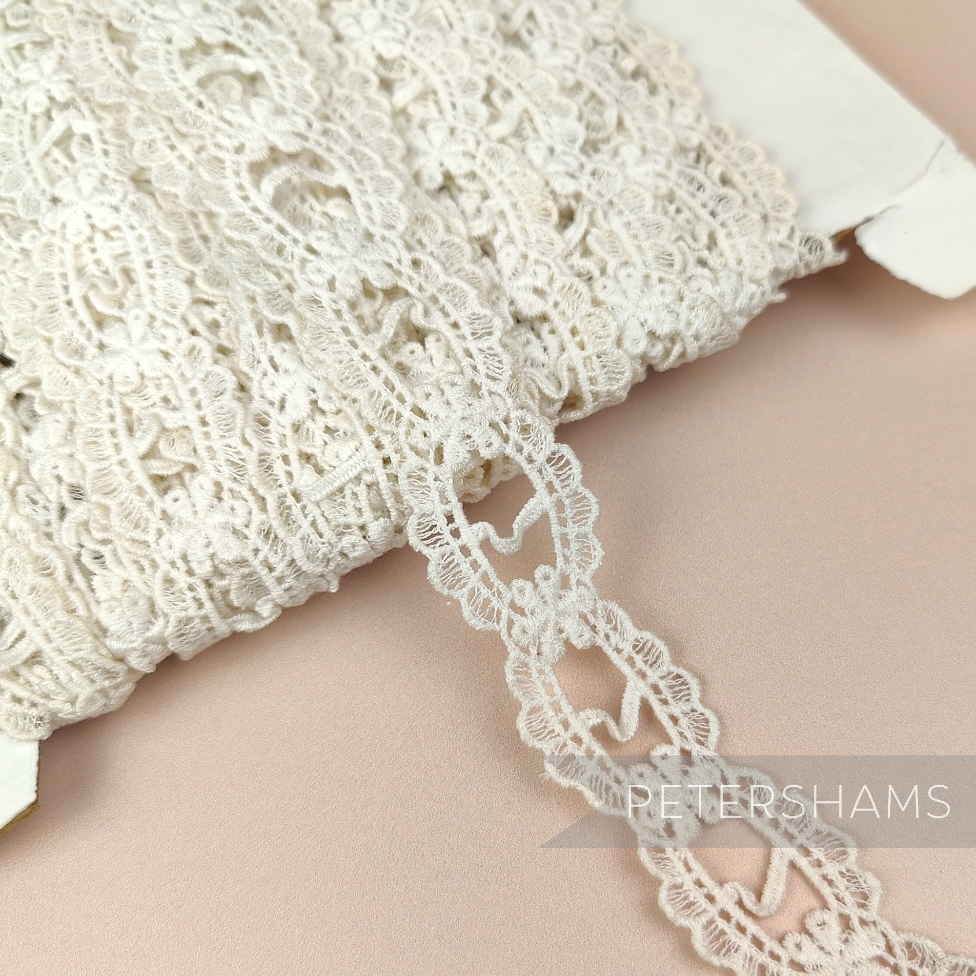 Petershams Millinery Supplies vintage 1950s ivory cotton guipure ribbon slot lace trim with a scalloped frame design.